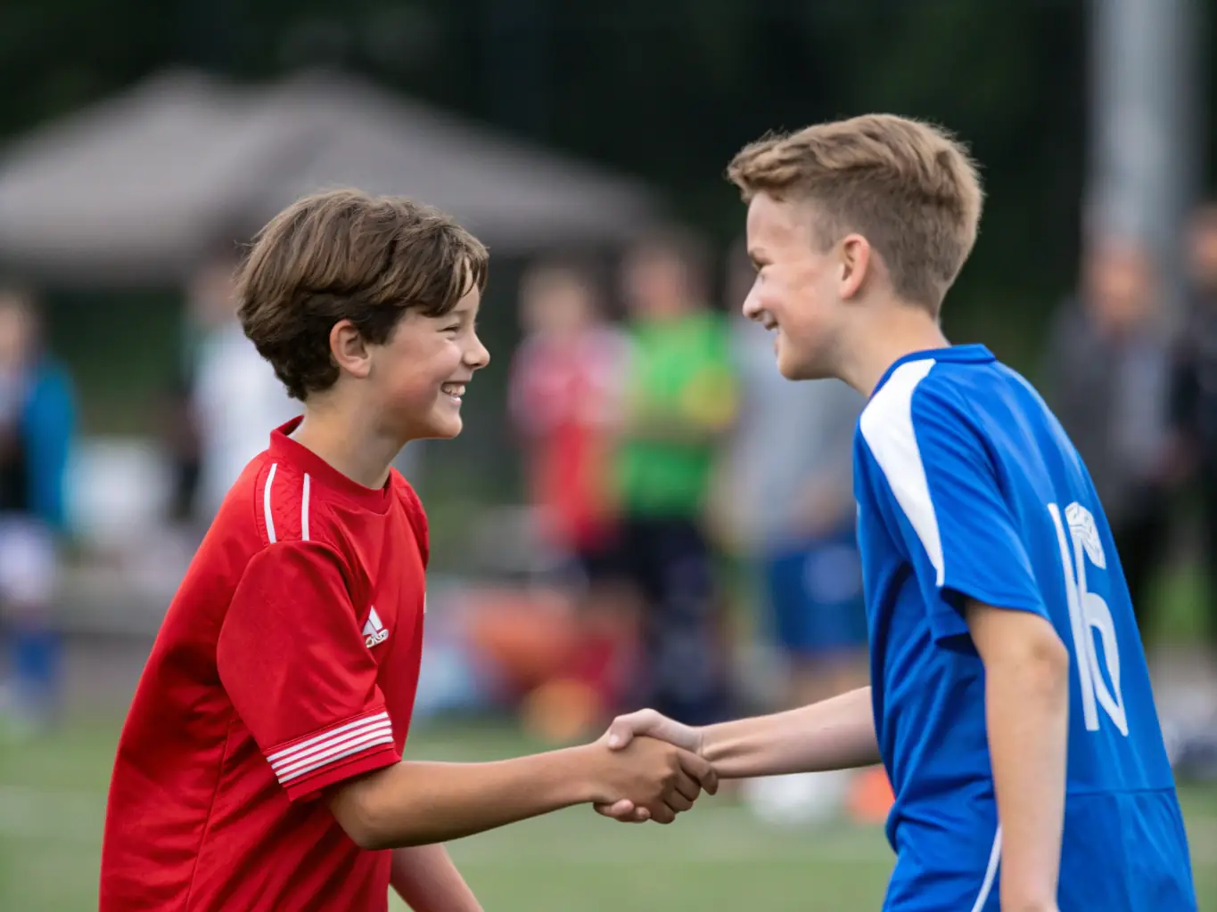 A student athlete shaking hands with an opponent after a match, demonstrating sportsmanship and mutual respect.